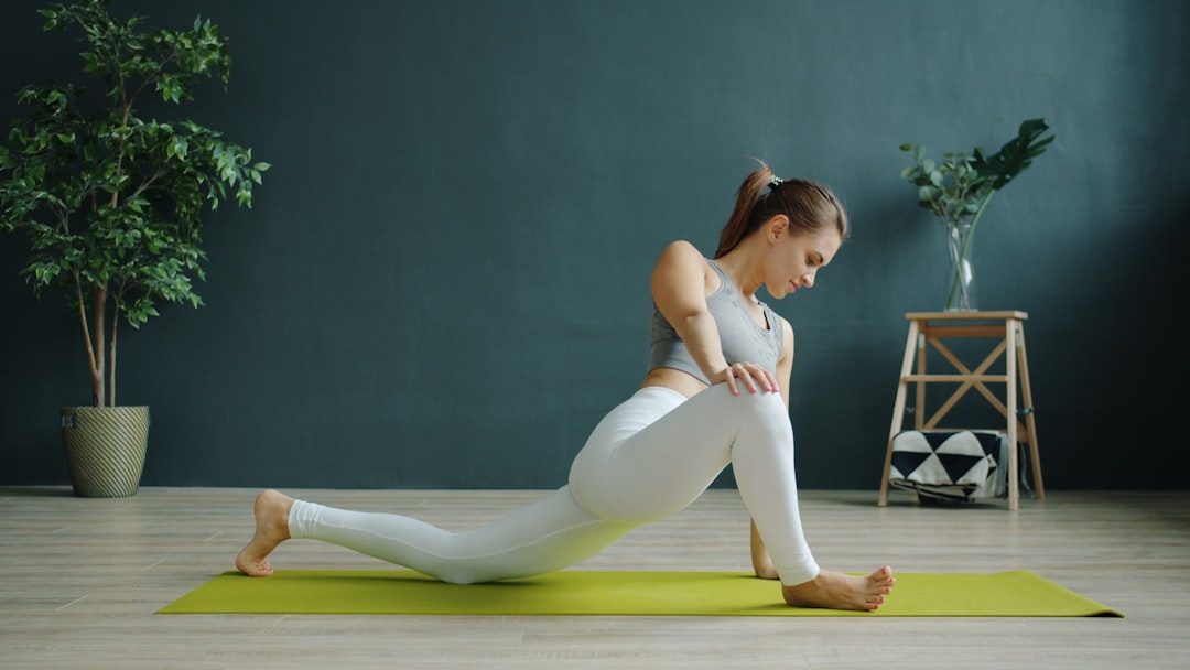 Menus Beautiful young woman working out indoors doing yoga alone in modern studio concentrated on individual practice. People, lifestyle and health concept.